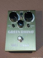 Top view of Way Huge Green Rhino pedal showing Volume, Drive, Tone knobs, frequency toggles, footswitch, and LED indicator.