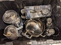 Photo showing a collection of kitchen and bathroom items including a food processor, Philips shower head in packaging, stainless steel bowls, a small cooking pot, metal rack, small grater, salt and pepper shakers.