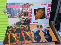 Four John Mayall vinyl albums displayed on a surface with two visible in front row and two behind, showing album cover art and condition of jackets.