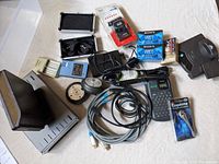 Image showing the wireless router, hard drive dock, label maker, VHS-C tapes, PC speakers, cables and headset in package.