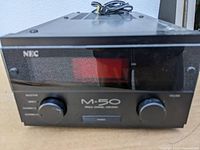 Front view of NEC M-50 single channel mono amplifier with two control knobs and black casing.