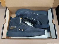 Pair of Nike SF AF1 MID sneakers in obsidian black inside open box showing side and top view.