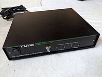 Front and top view of the Pod 1 Bi-Directional Audio Interface showing power switch, output adjust knob, LED indicator, and product labeling.