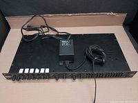 Front and top view of the black metal rackmount Rane CP 64 commercial audio processor with attached power supply cable.