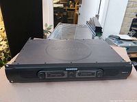Front and top view of black Samson Servo 200 power amplifier with dual volume controls and LED meters.