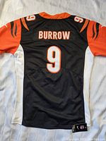 Back view of the jersey showing 'BURROW' and number 9 in orange and white on black fabric with orange sleeves and tiger stripe detailing.