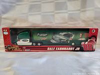 Front view of the transport truck model in original packaging, highlighting AMP branding, Dale Earnhardt Jr. image, and number 88 on trailer.
