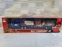 Side view of the Dale Earnhardt Jr. National Guard transport model truck in its original red Winner's Circle NASCAR box, showing detailed graphics and branding.