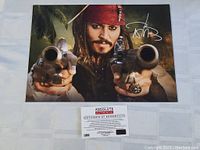Full view of the signed 8x10 photo with certificate of authenticity below it.