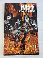 Front cover of KISS Psycho Circus comic book with band members illustrated in dramatic makeup, intense orange fiery background, and a car with figures in foreground.