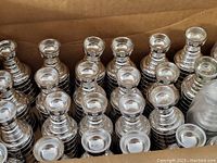 Photo showing a large quantity of silver mini Stanley Cup trophies packed together.