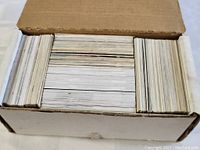 Cardboard box filled with many hockey cards stacked and arranged tightly.