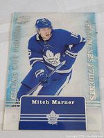 Front view of Mitch Marner acetate hockey card in Toronto Maple Leafs uniform with clear style and 'Clear Cut Phenoms' text.