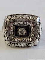 Front view of replica ring showing Pittsburgh Steelers 1974 World Champions with central clear stone.