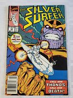 Front cover image showing The Silver Surfer #34 comic book with Silver Surfer and large image of Thanos on the cover. Priced $1.00, published by Marvel Comics.