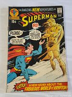 Front cover of the comic showing Superman and the golden humanoid figure with the title and issue details.