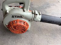 Side view of blower housing showing Stihl logo and orange fan cover