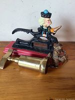 Cast iron nutcracker and brass corkscrew side by side with bear keychain visible.