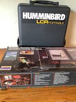 Custom carrying case for the Humminbird LCR portable fish finder and original product box with fishing and weather resistance images.