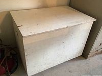 Closed view of the large white rolling plywood storage box showing front and one side.