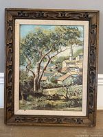 Full view of the framed oil painting depicting a village landscape with a prominent tree and church steeple.
