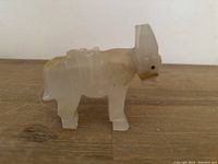Front angled view of the translucent onyx mule figurine showing carved ears, legs, and dark embedded eyes.