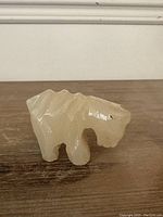 Side view of the small onyx tiger figurine showcasing its carved body details and texture of the stone.
