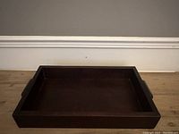 Top view of vintage rosewood serving tray showing clean and smooth surface with raised edges and handles on both ends.