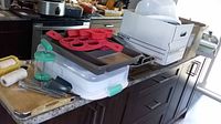 Overview of bakeware and kitchen tools on countertop including silicone molds and trays.