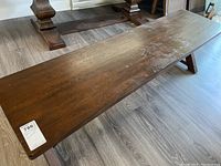 Top view of the bench showing full length and dark wood surface with visible scratches and scuffs.