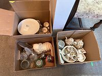 Box with assorted porcelain dishes, cups, plates, and decorative items packed inside