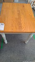 Top view of the wood grain square table top with light wear marks.