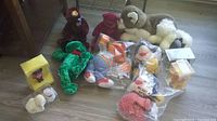Various stuffed toys including teddy bears, dog, frog, tiger, character dolls, some packaged in plastic bags.