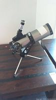 Magnicon telescope mounted on tripod standing on table showing the main body and lens extension