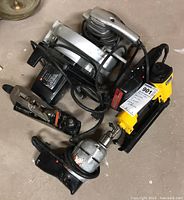 Photo showing all four tools together: circular saw, drill, sabre saw, and pneumatic brad nailer
