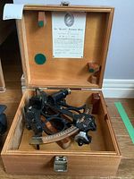 Wooden box open showing sextant and Certificate of Examination mounted on lid