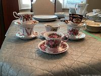Photo showing six Royal Albert tea cups and matching saucers with various floral patterns, arranged on a table.