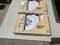 Photo showing two boxed 20-piece dinnerware sets with floral design containing full service for 4, labeled ApolloWare Melmac Melamine Deluxe Dinnerware made in USA