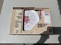 Two unopened boxes of Apolloware Melmac deluxe dinnerware 20 piece sets showing floral decorated plate design through window on the boxes.