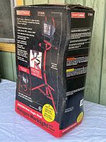 Sealed original box showing Craftsman branding and product details including wattage, light levels and tripod stand features
