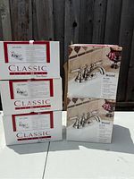 Three boxed Price Pfister Classic Series 443-6000 faucets stacked beside two boxed Price Pfister Bristol 48-CTOK faucets