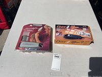 Two boxed hair trimming kits on a white surface, Oster and WAHL Homestyler, with lot number card.