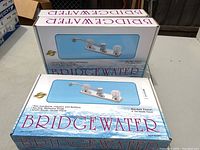 Photo of three boxed Bridgewater kitchen faucet kits showing sealed packaging and brand name.