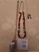 Full view of amber necklace and matching earrings with measuring tape showing necklace length about 11.5 inches