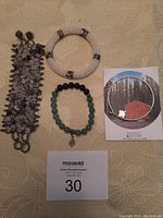 Full set of four bracelets on beige surface with auction card