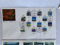 First day cover with 14 Canadian stamps arranged diagonally with cancellation marks from St. Catharines, Ontario, dated 1992-02-06, includes a colored photo of maple leaves.