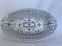 Top view of an oval Delft china basket with blue floral and geometric decoration, showing the intricate open lattice sides and detailed painting inside the basket.