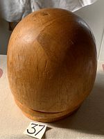 Full view of the rounded wooden hat block showing its dome shape and natural wood grain.