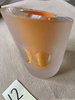 Front view showing frosted matte glass with orange interior and starfish shapes hollowed out sides