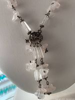 Close-up view of toggle clasp and necklace beads showing pink crystal quartz chips and clear cylindrical quartz beads linked with sterling silver chain.